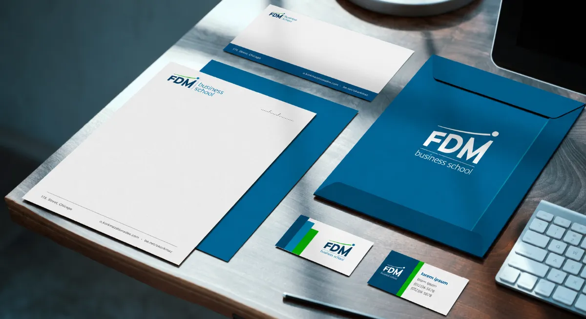 Papelaria da FDM Business School em azul: papel timbrado, cartões e envelope
